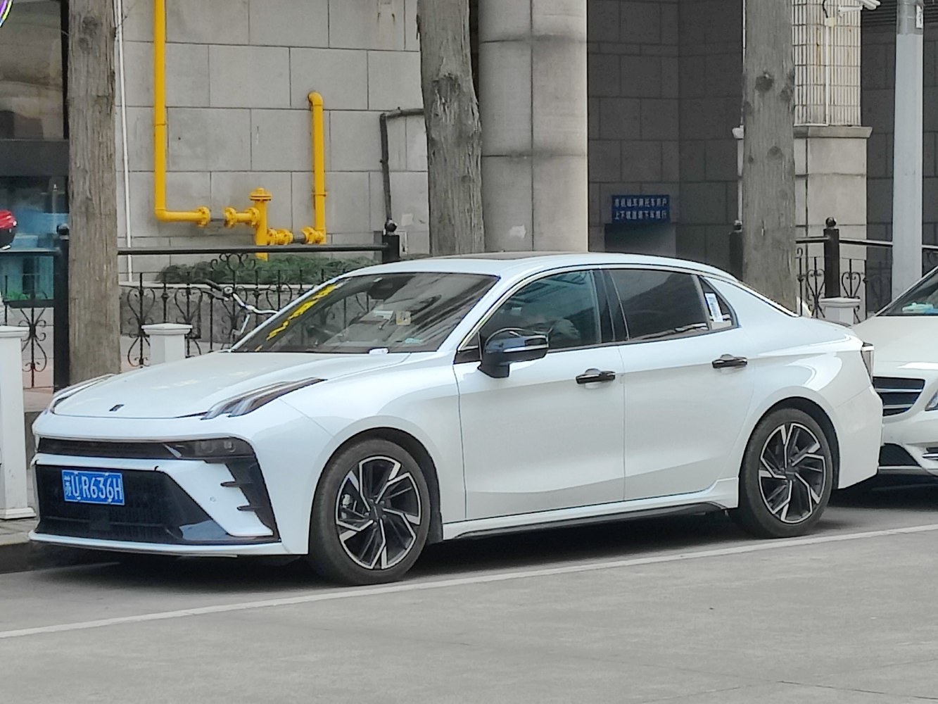 White sporty sedan showing side profile and distinctive front lighting