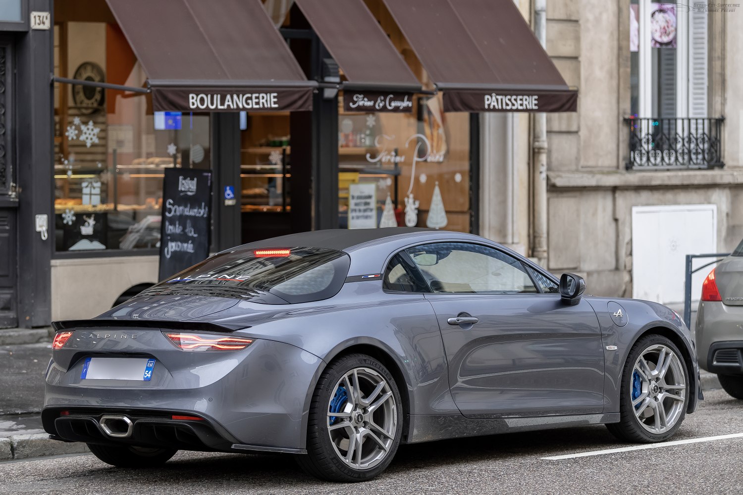 Rear side view of sleek sports coupe with alloy wheels and aerodynamic rear.