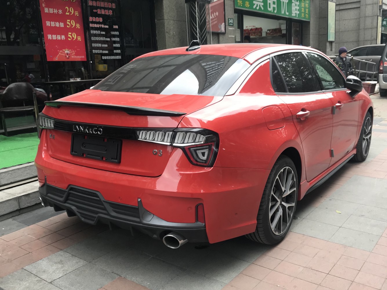 Red sedan showing distinctive rear tail lights and sporty diffuser.