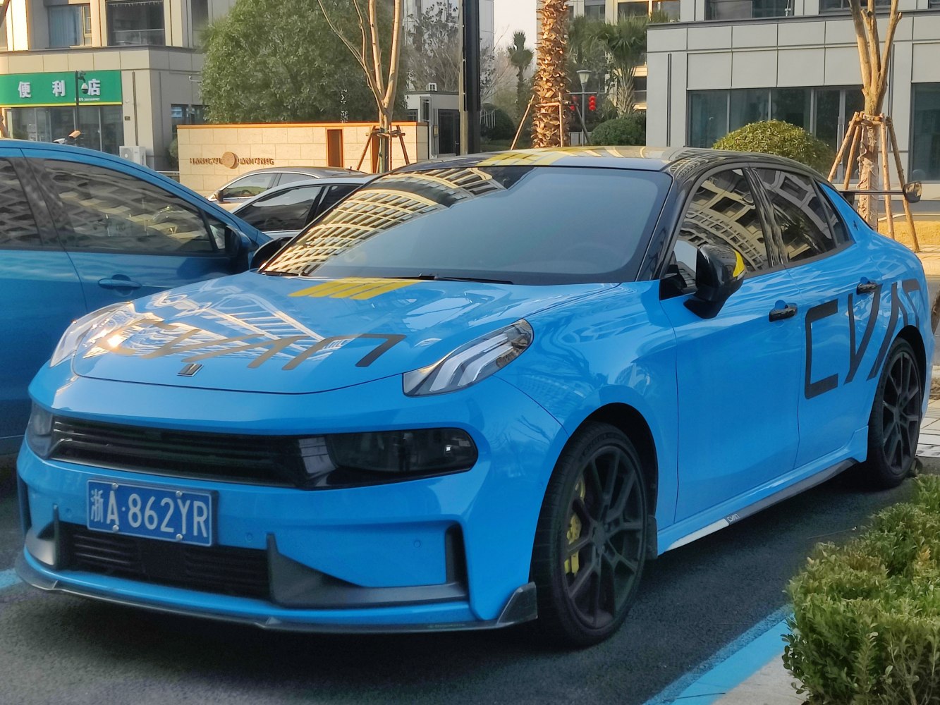 Blue sedan with black wheels and unique sporty decals