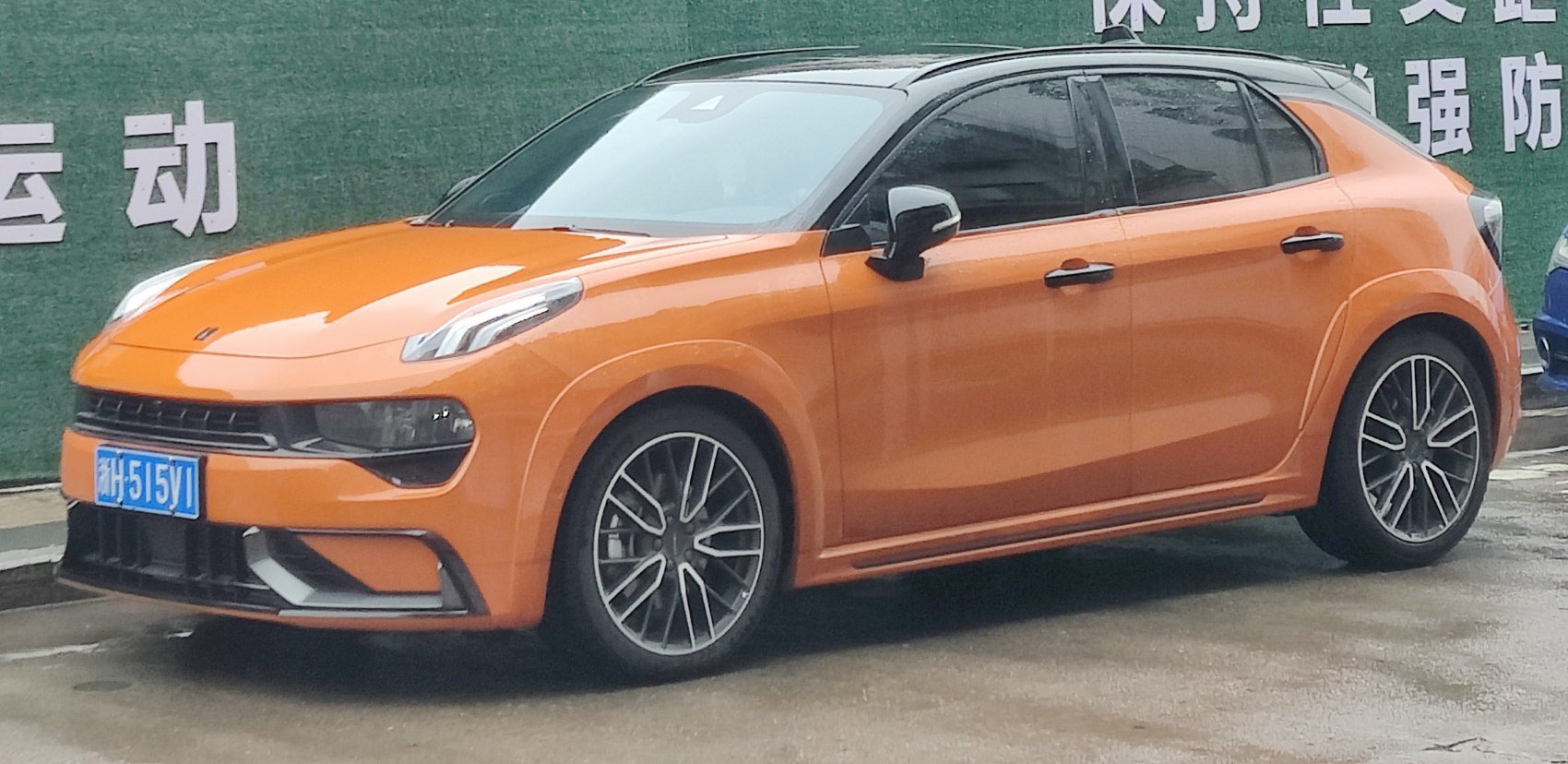 Orange and black two-tone hatchback with sleek headlights and sporty alloy wheels
