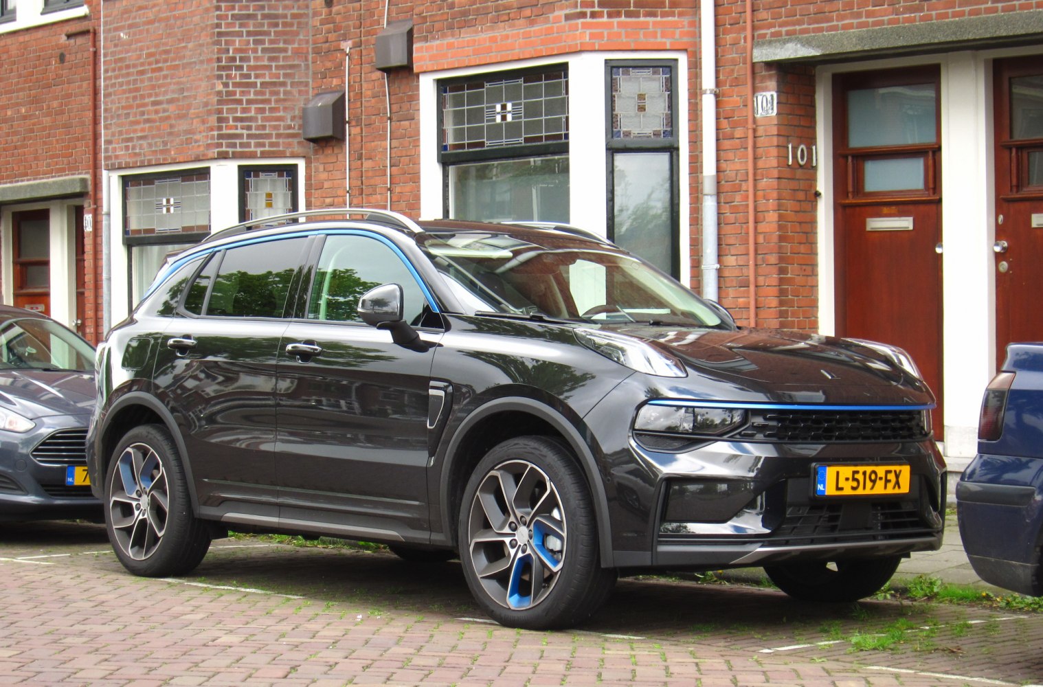 Black SUV side-front view with blue-accented wheels and LED headlights