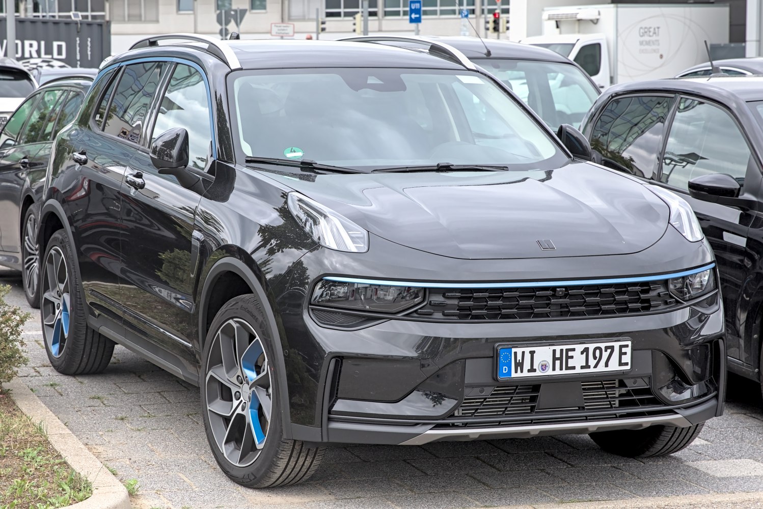 Front view with grille and blue-accented alloy wheels