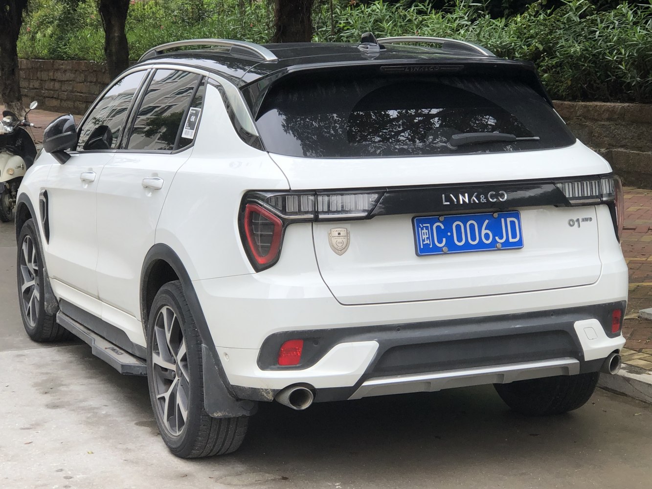 Rear view of SUV with distinctive taillights and roof rails in white color