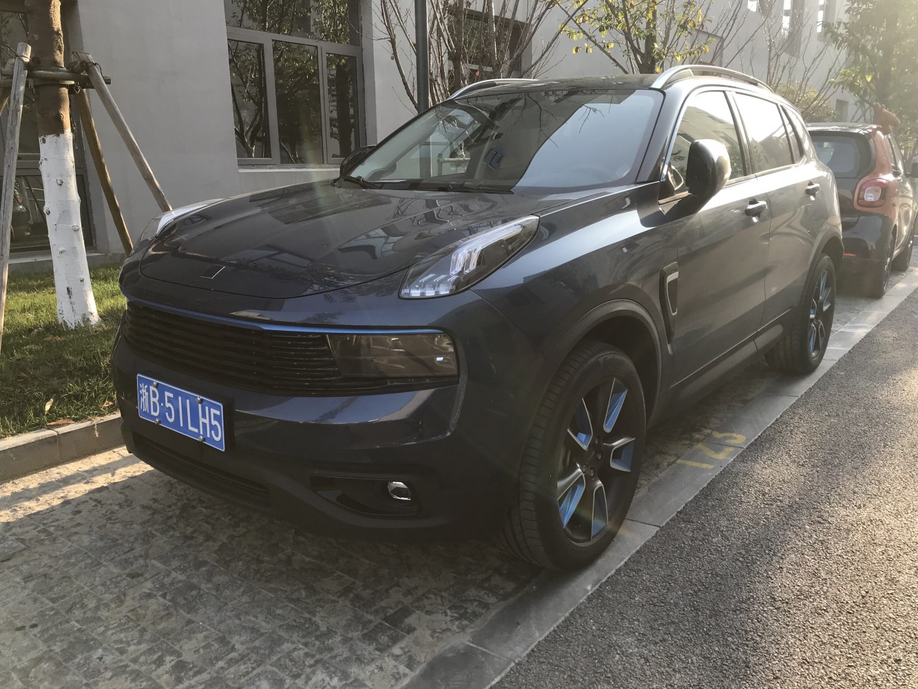 Front-side view of an SUV with distinctive headlights and alloy wheels.