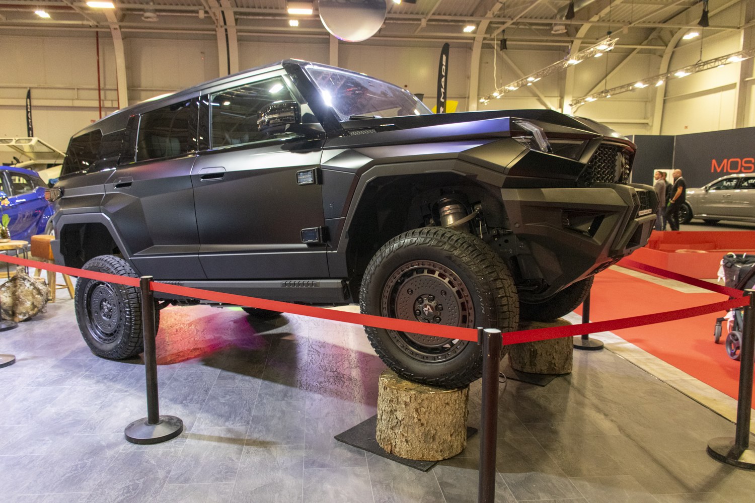 Matte black off-road SUV with heavy-duty tires and angular body.