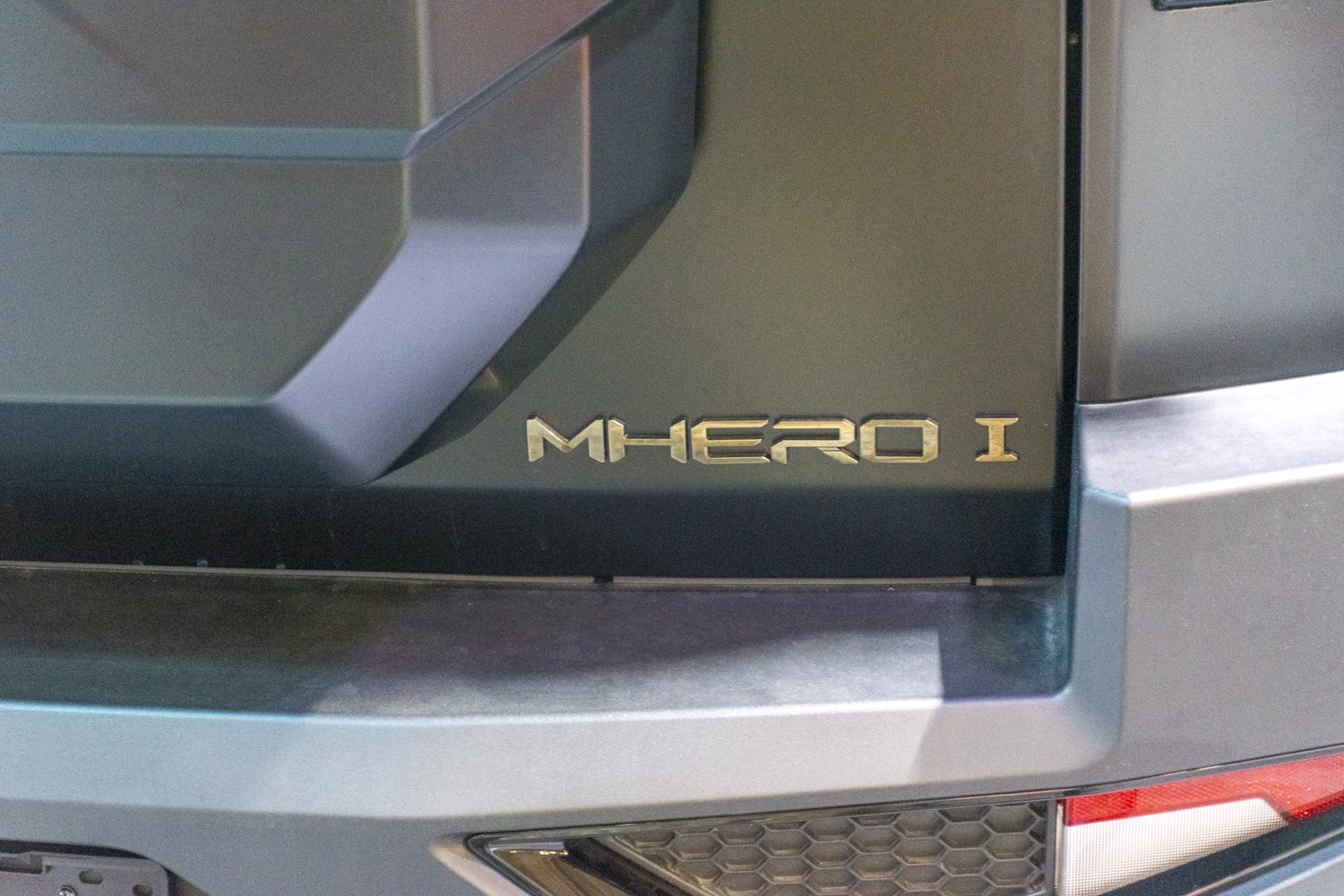 Close-up of emblem on rear door panel with sharp geometric design.