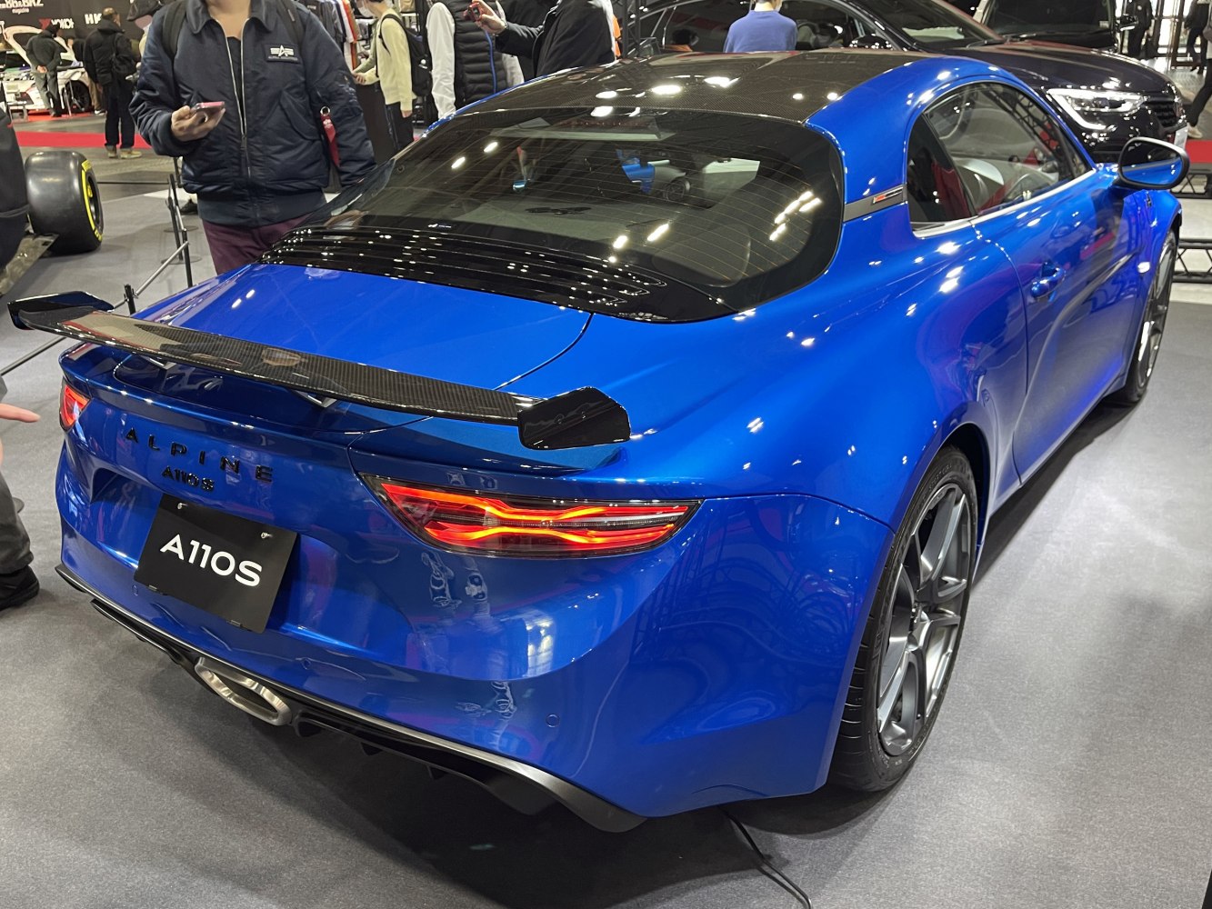 Carbon fiber rear spoiler and LED tail lights on blue sports coupe