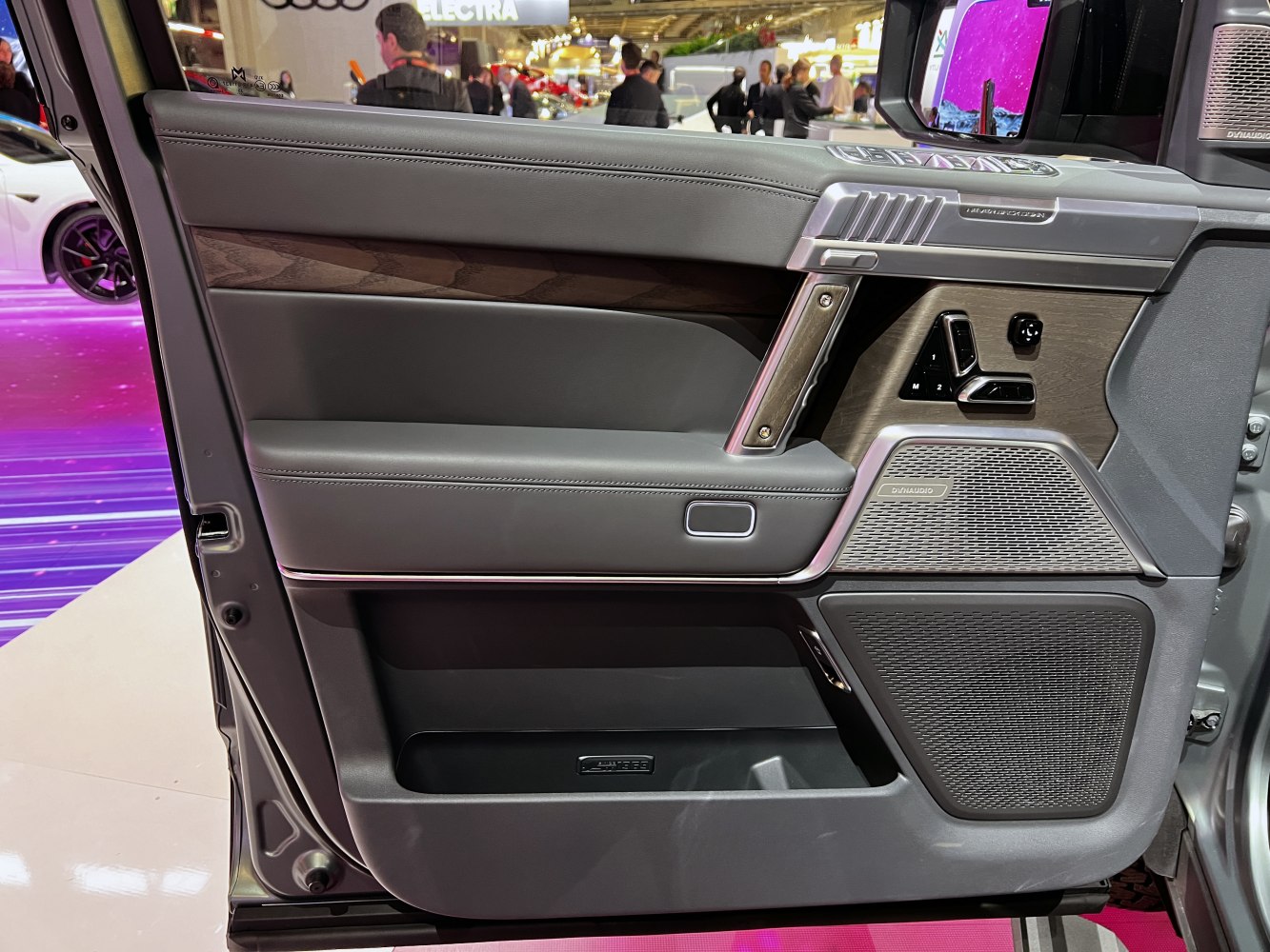 Premium car door panel with leather, wood trim, and Dynaudio speakers