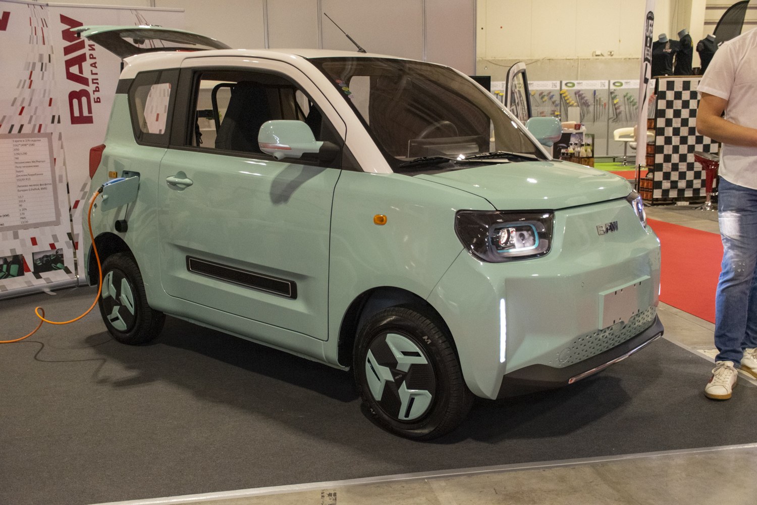 Compact electric vehicle with geometric wheels charging indoors.