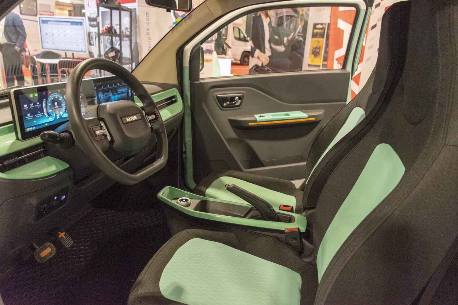 Digital dashboard and mint green trimmed seats with modern steering wheel