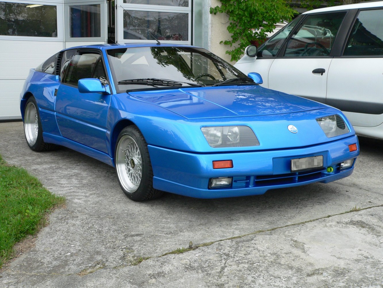 Classic blue sports coupe with distinctive angled headlights and alloy wheels