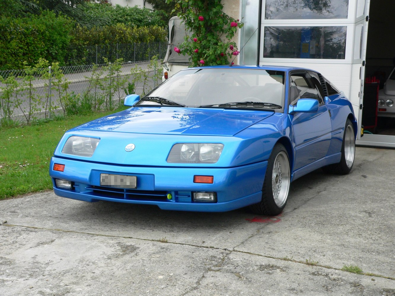 Blue sports coupe with rectangular headlights and distinctive front design