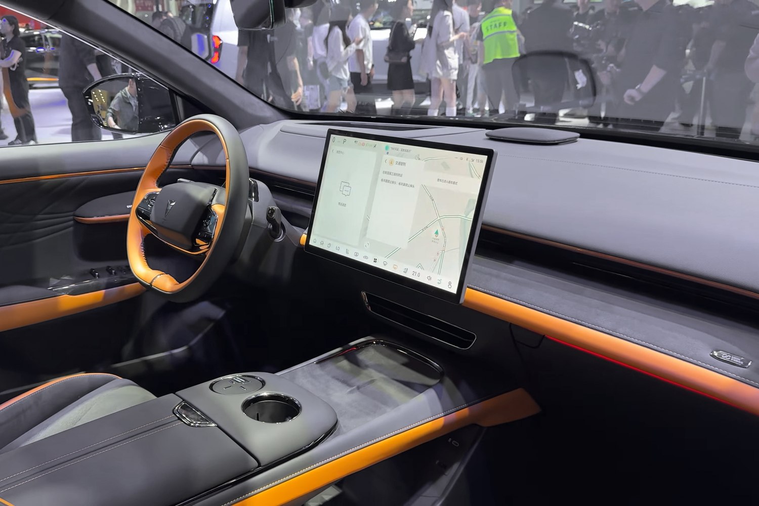 Large central touchscreen and modern steering wheel with orange accents