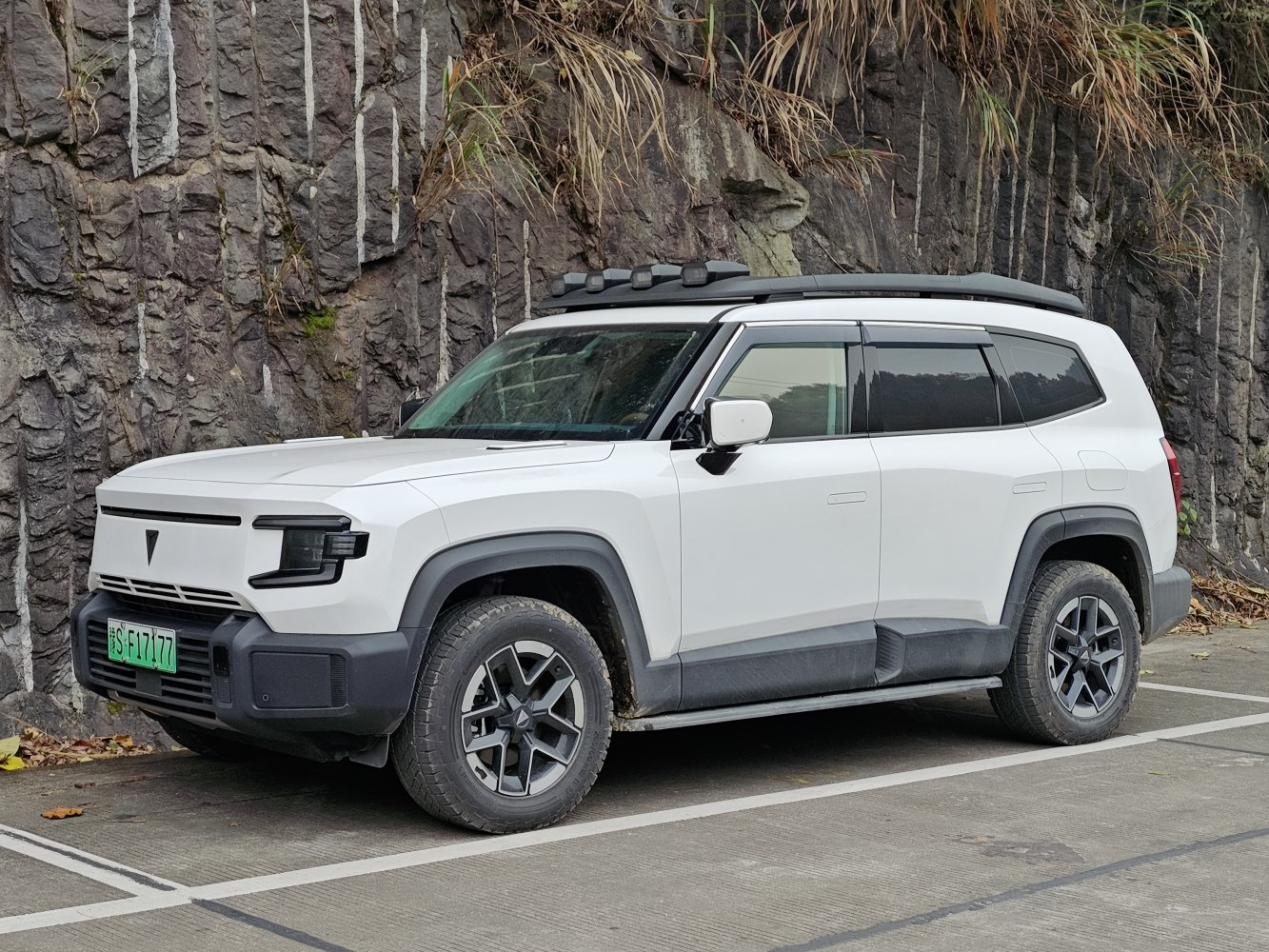 White electric SUV with roof rack lights and rugged off-road styling