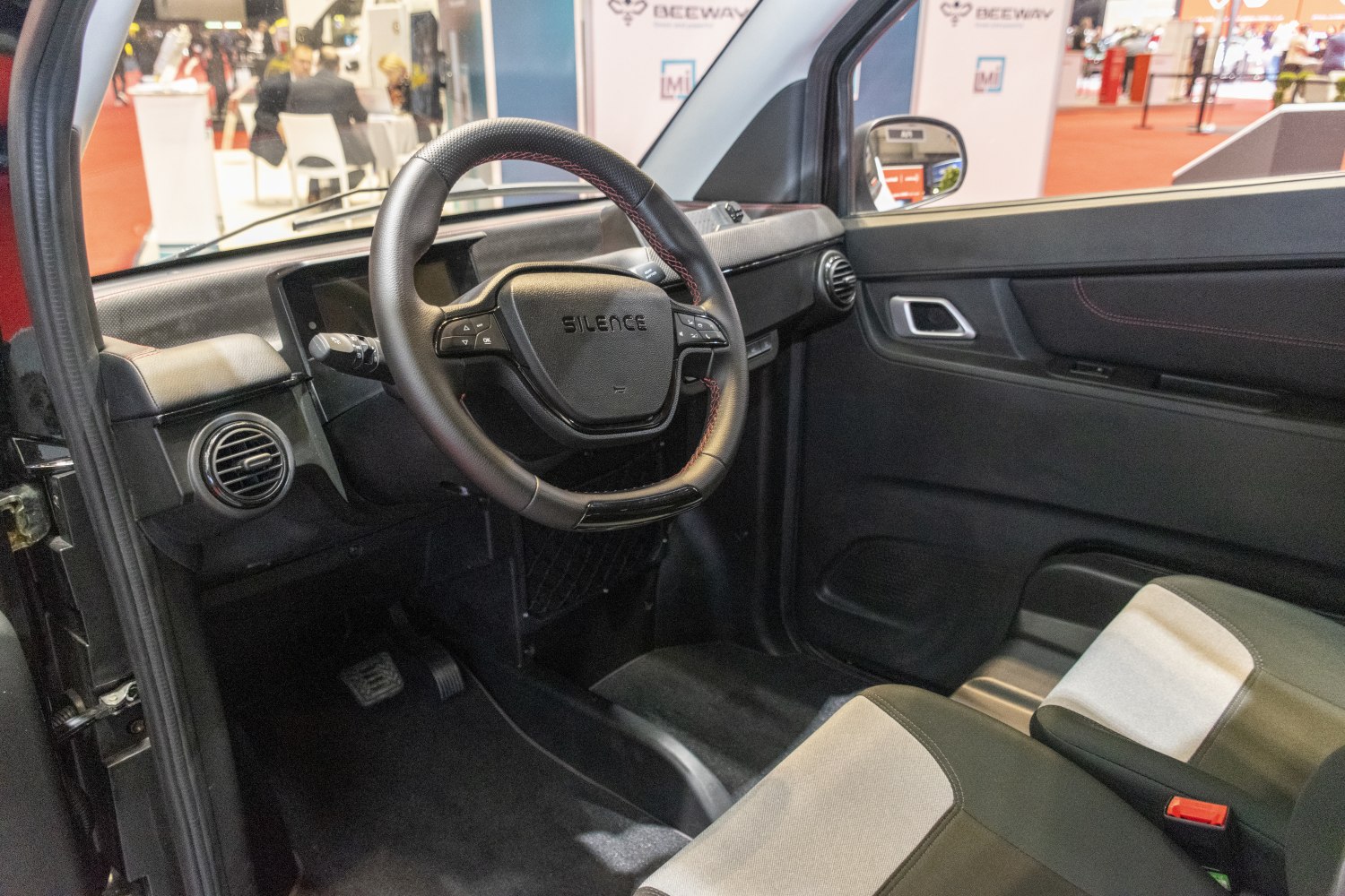 Steering wheel and dashboard with control buttons, compact car interior seating