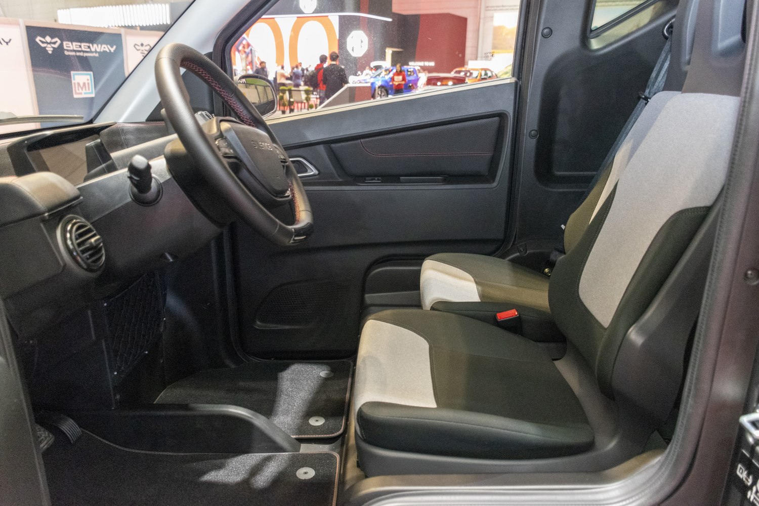 Dashboard, steering wheel, and dual-tone front seats inside a compact vehicle
