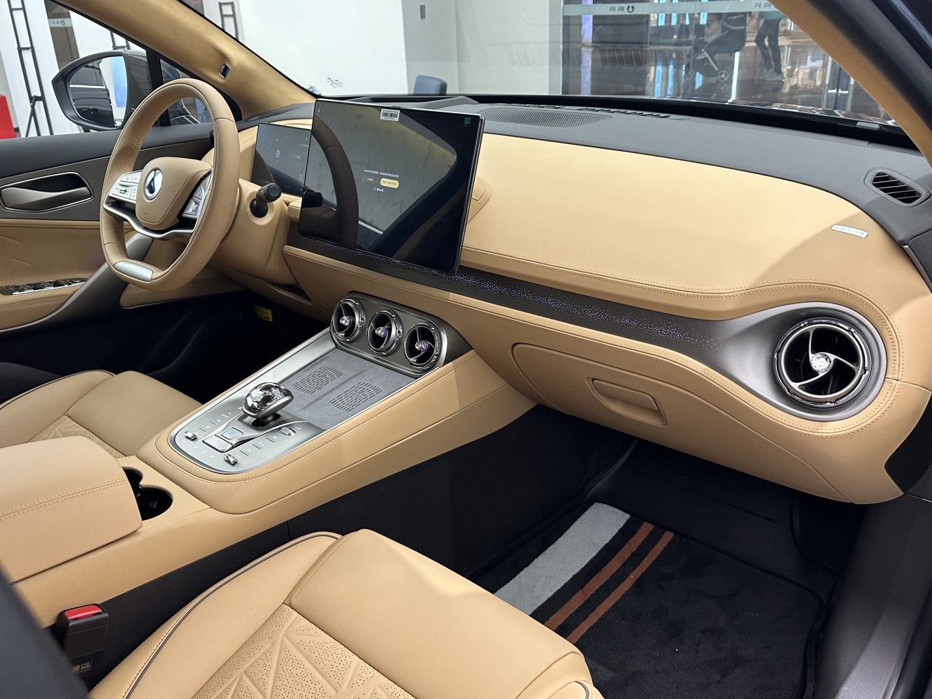Dual digital screens and beige leather interior with modern air vents