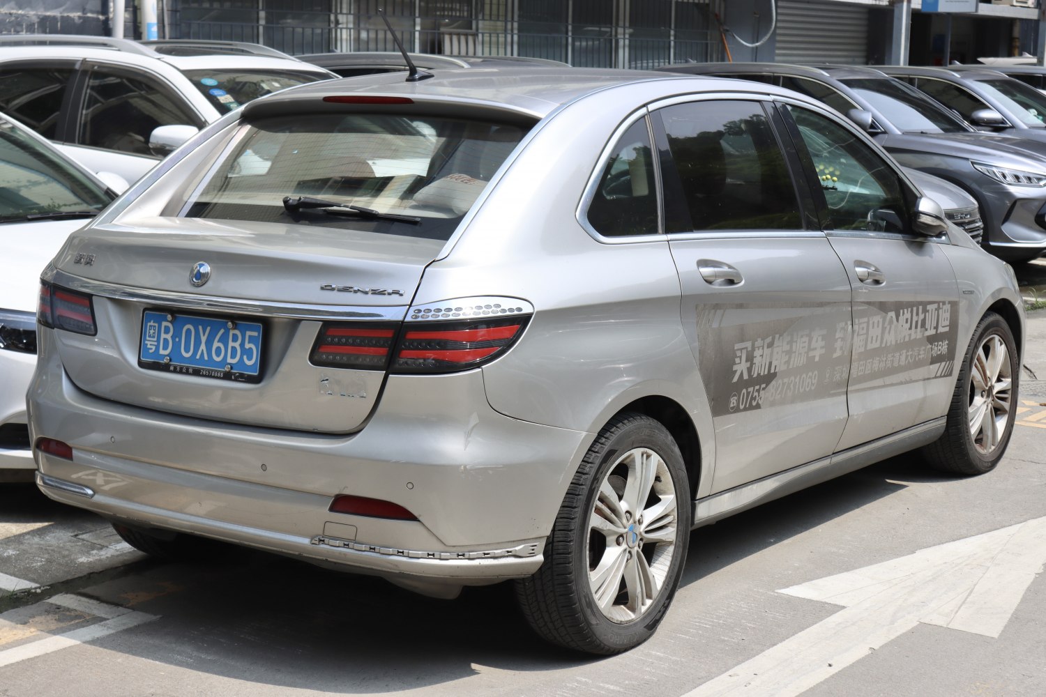 Silver electric vehicle rear with unique taillights and roof antenna
