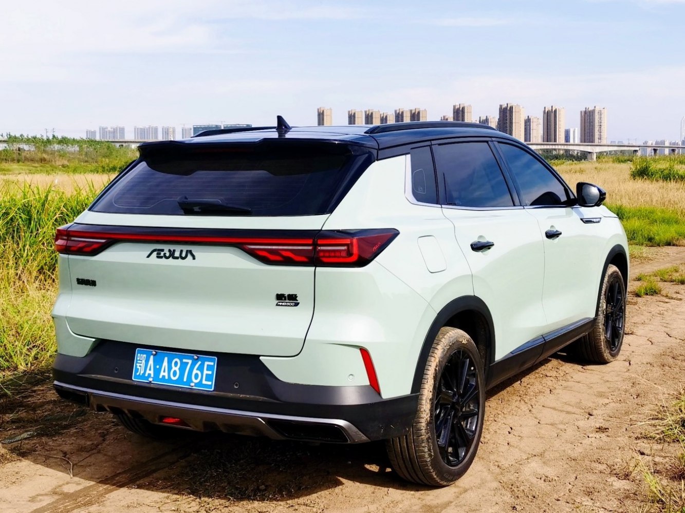 SUV rear view with sleek taillights and black alloy wheels on dirt road