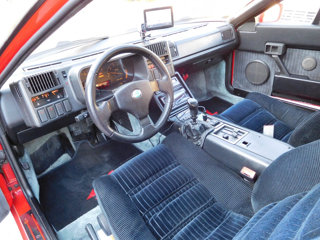 Manual gear lever and steering wheel in classic 1980s car interior