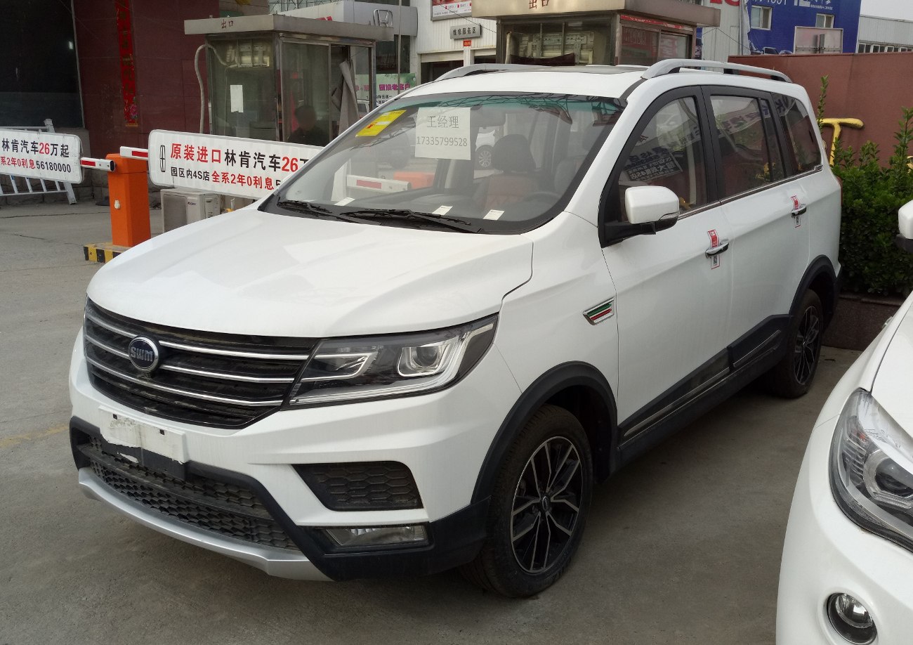 Front and side view of white SUV with multi-bar grille and alloy wheels