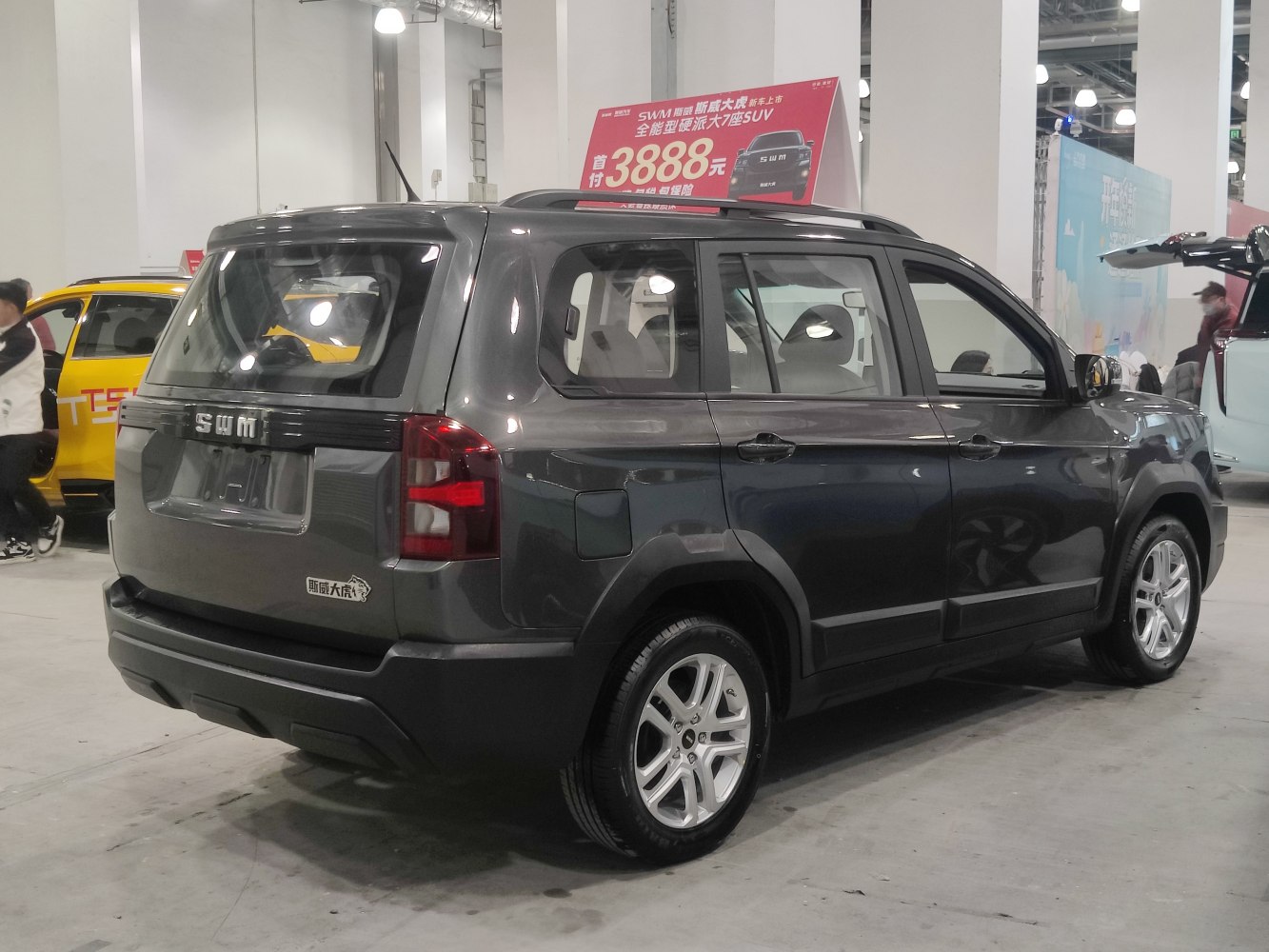 Boxy SUV rear side view with dark gray paint and alloy wheels