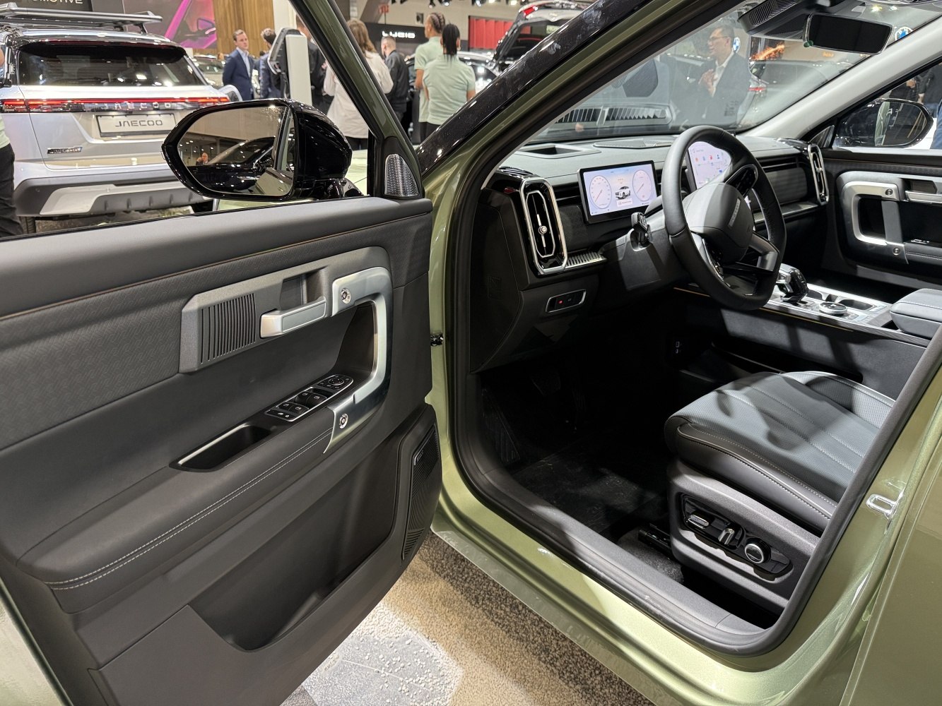 Open driver door interior and dashboard with digital displays and controls