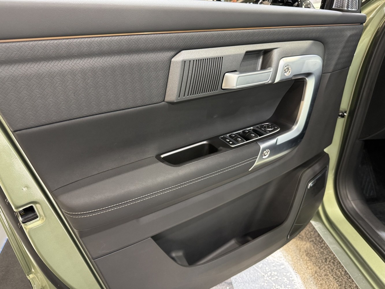Door interior panel with window controls and storage compartments