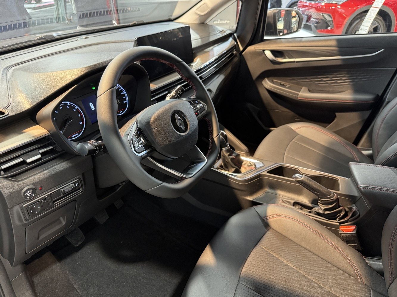 Interior dashboard, steering wheel, and seating with modern controls and upholstery