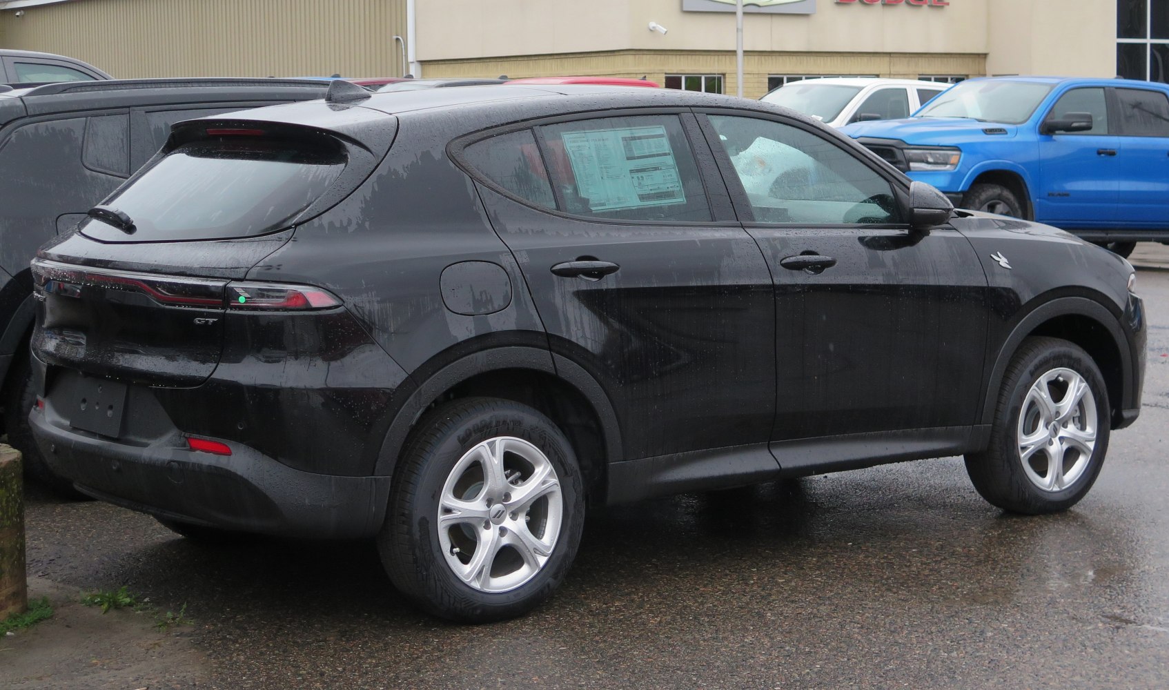 Black hatchback rear side view with roof spoiler and modern tail lights.