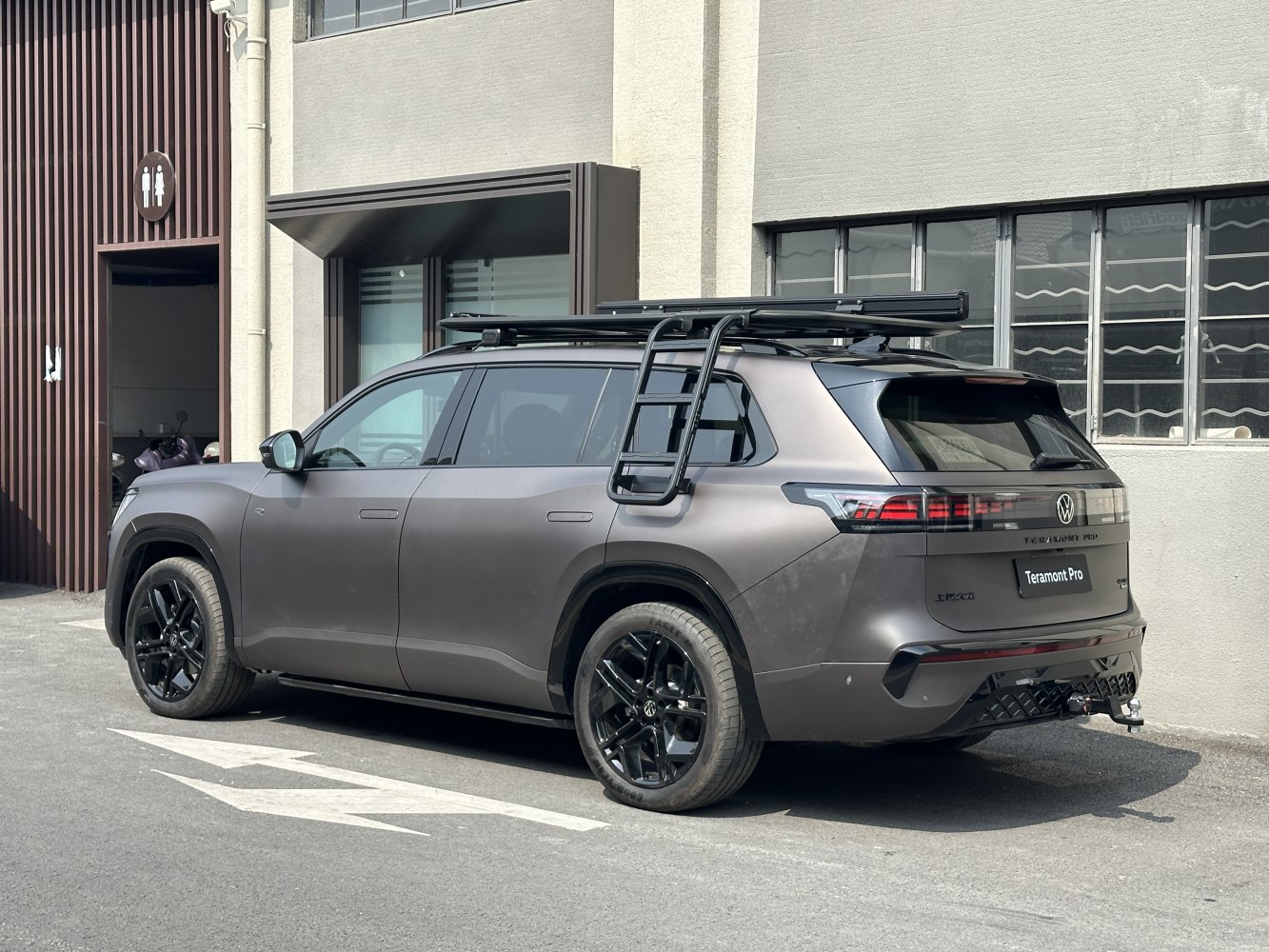 Matte SUV with roof ladder, black wheels, and towing hitch