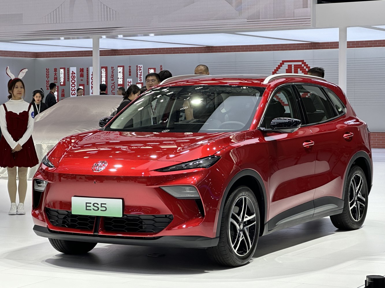 Front and side view of a red electric SUV with modern headlights and alloy wheels