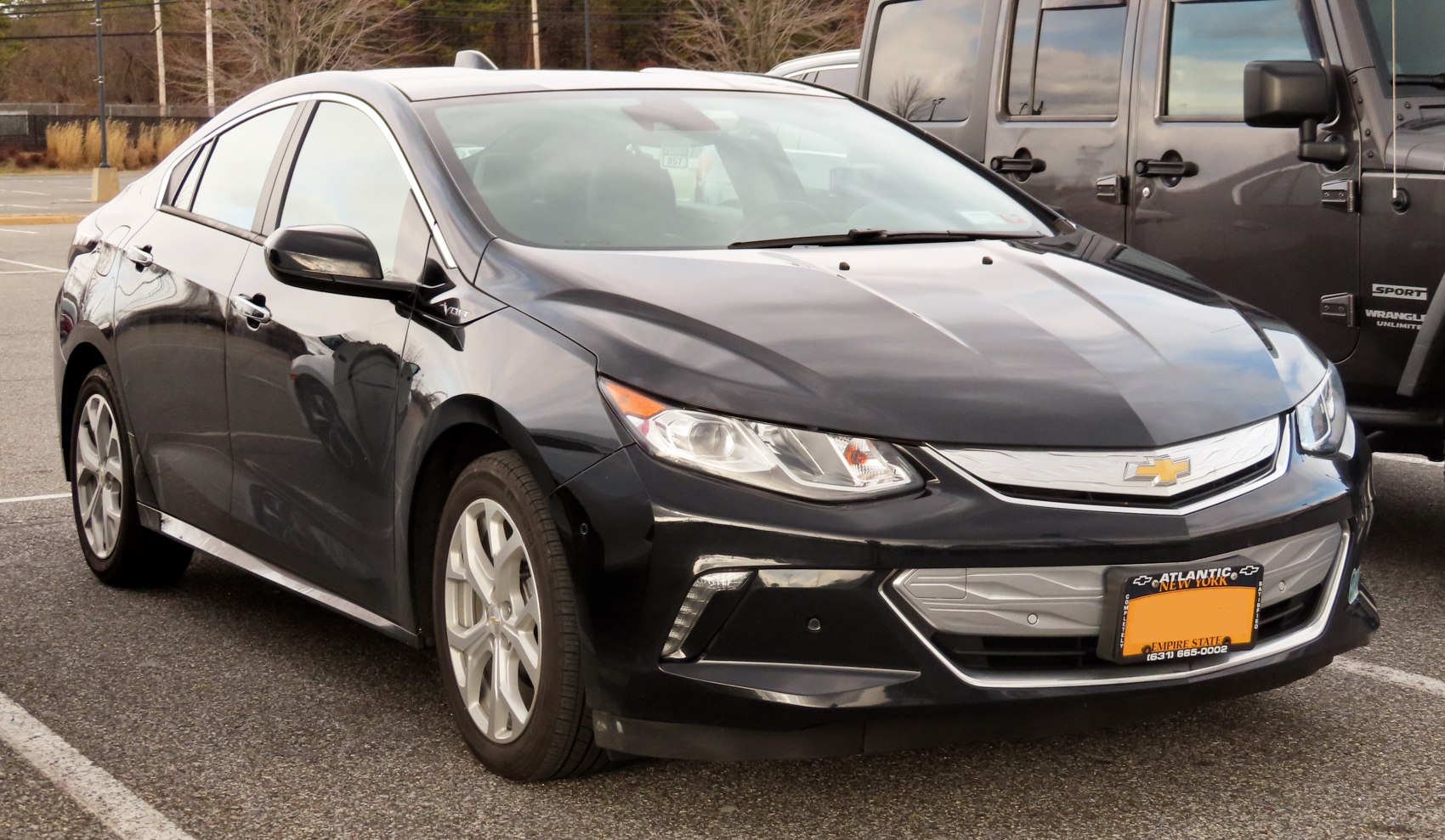 Front-side view of a sleek black electric sedan with aerodynamic headlights