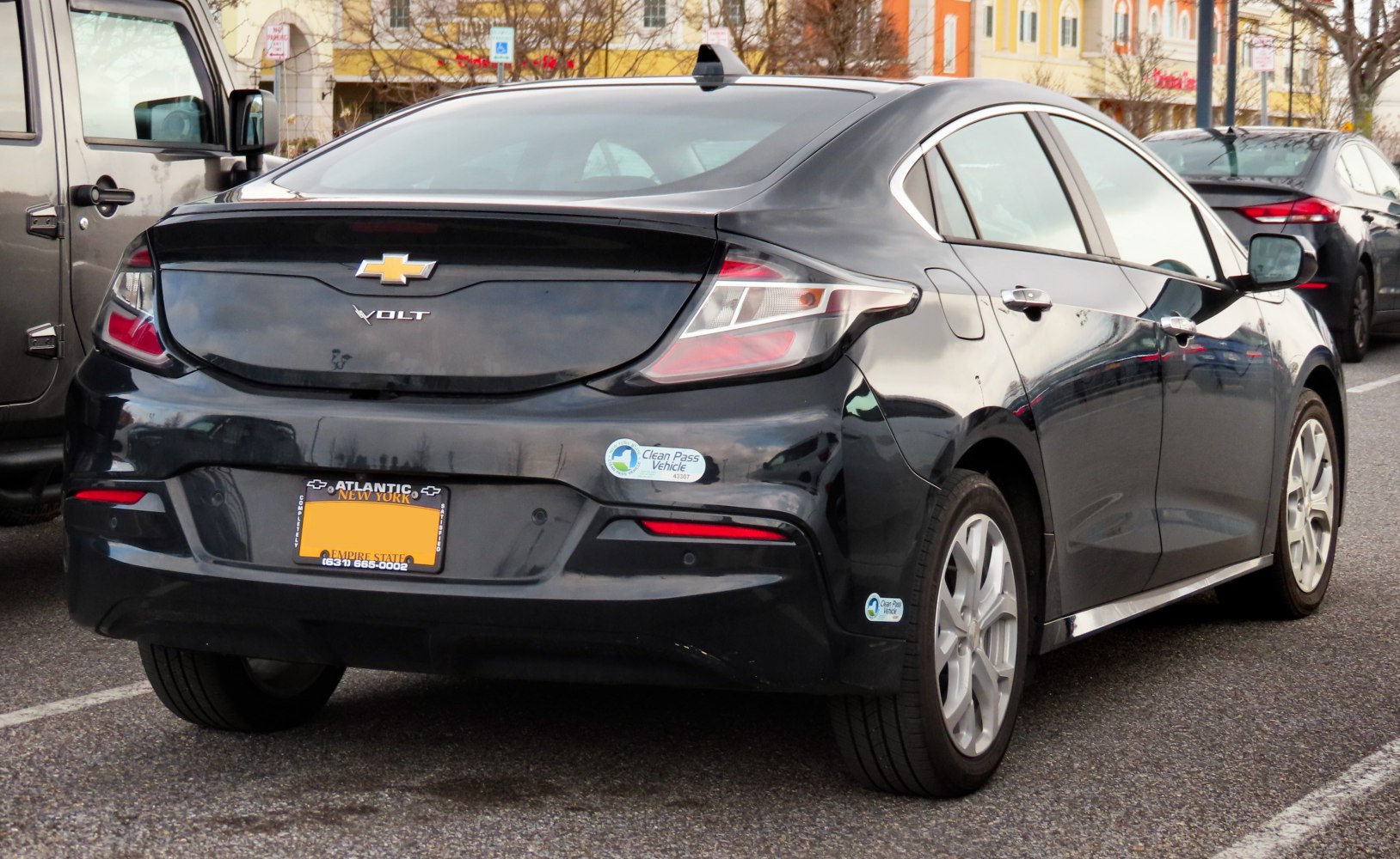 Rear view of a mid-size sedan with distinctive tail lights and Clean Pass Vehicle badges.
