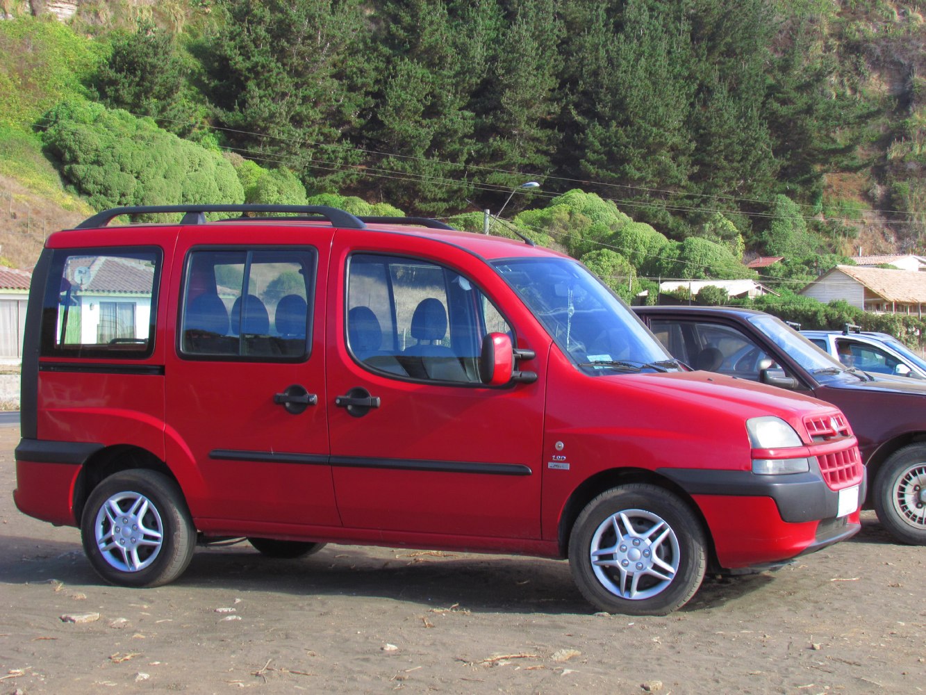 Red multipurpose vehicle side view with roof rails and alloy wheels