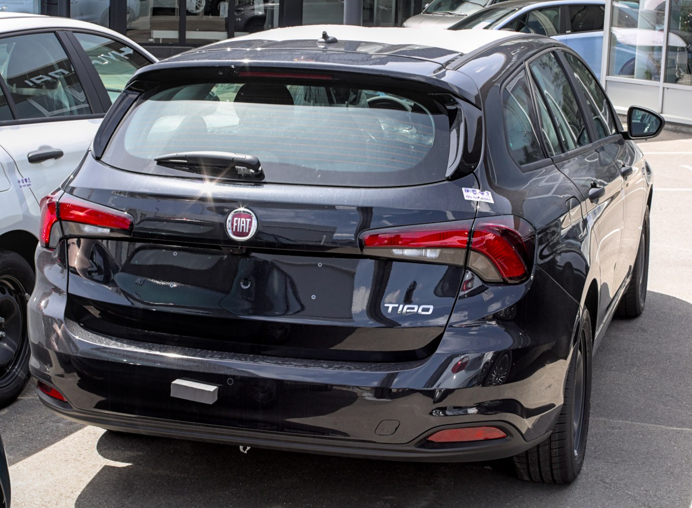 Rear lights, hatch, and rear windshield wiper of a black wagon.