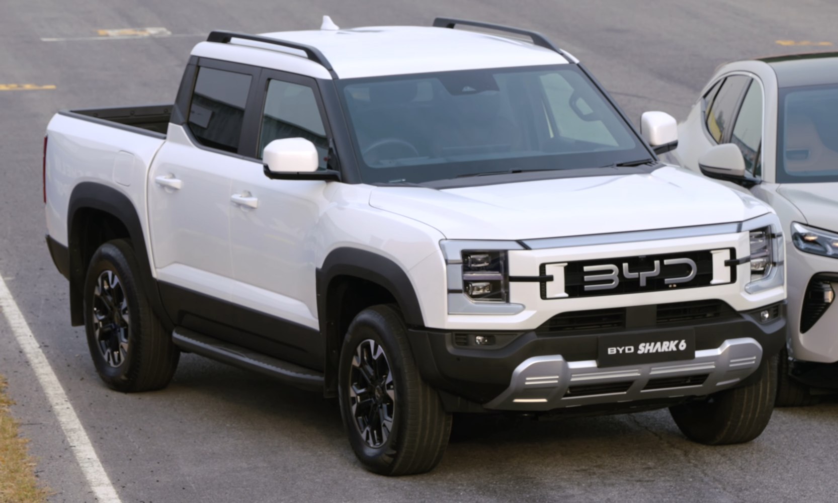 Front and side view of an electric pickup with LED headlights and bold grille