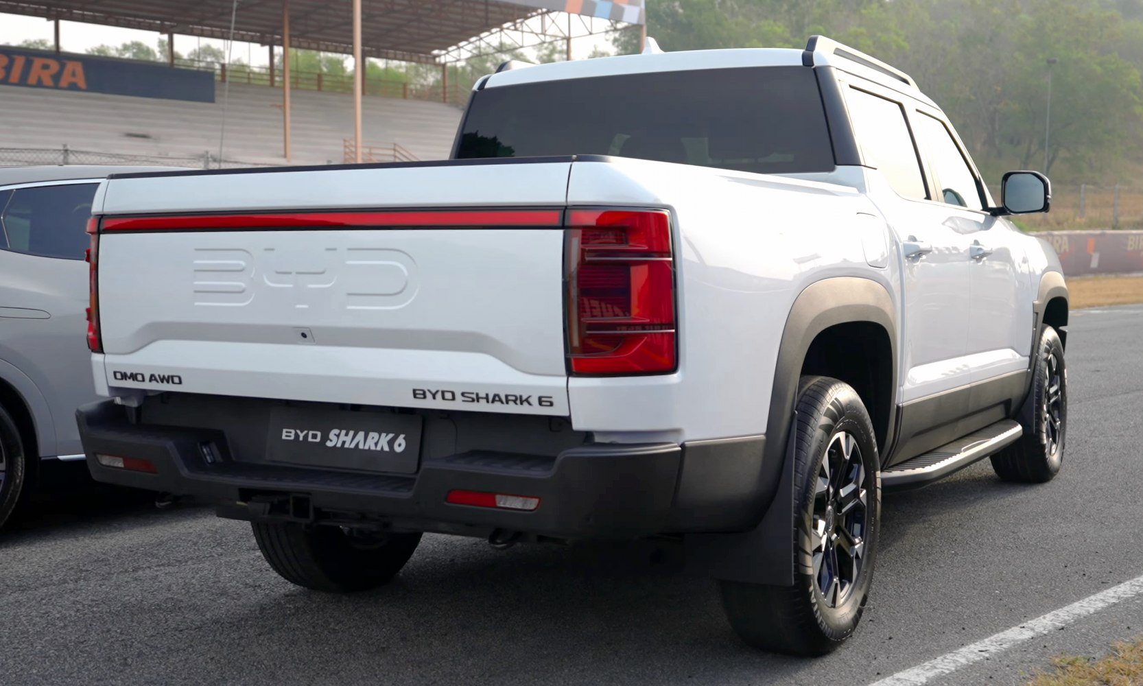 Rear view of a white pickup with AWD, embossed tailgate, LED tail lights