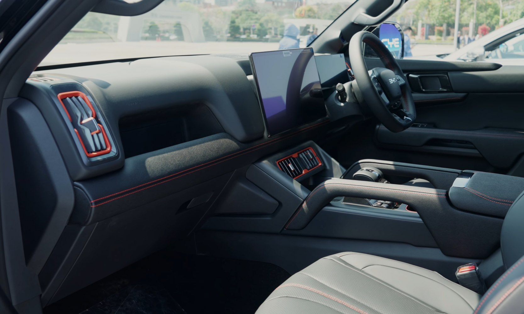 Modern dashboard with dual infotainment screens and red stitching accents