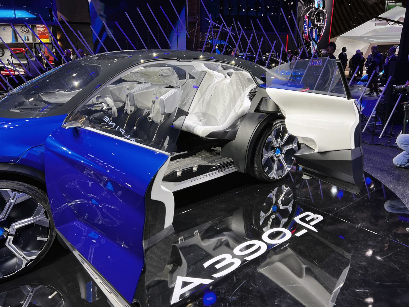 Open doors reveal futuristic white interior and modern wheel design