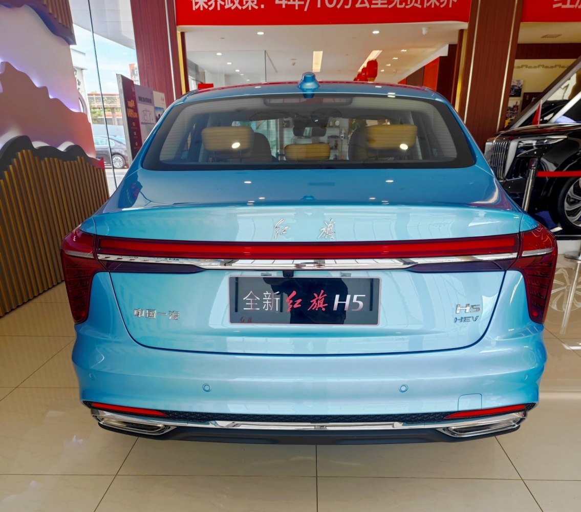 Full-width taillight and rear HEV badge on blue sedan