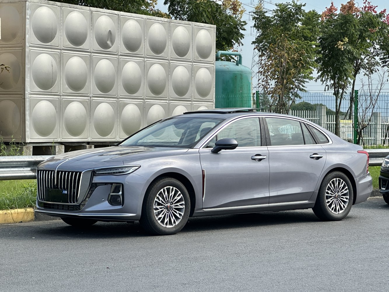 Prominent vertical grille and multi-spoke alloy wheels on luxury sedan.