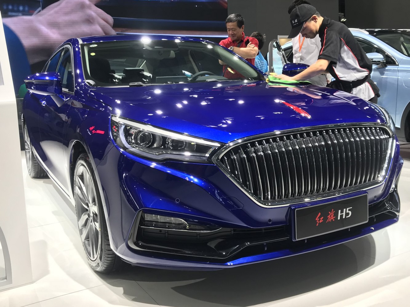 Chrome vertical slat grille with LED headlights on a modern sedan front