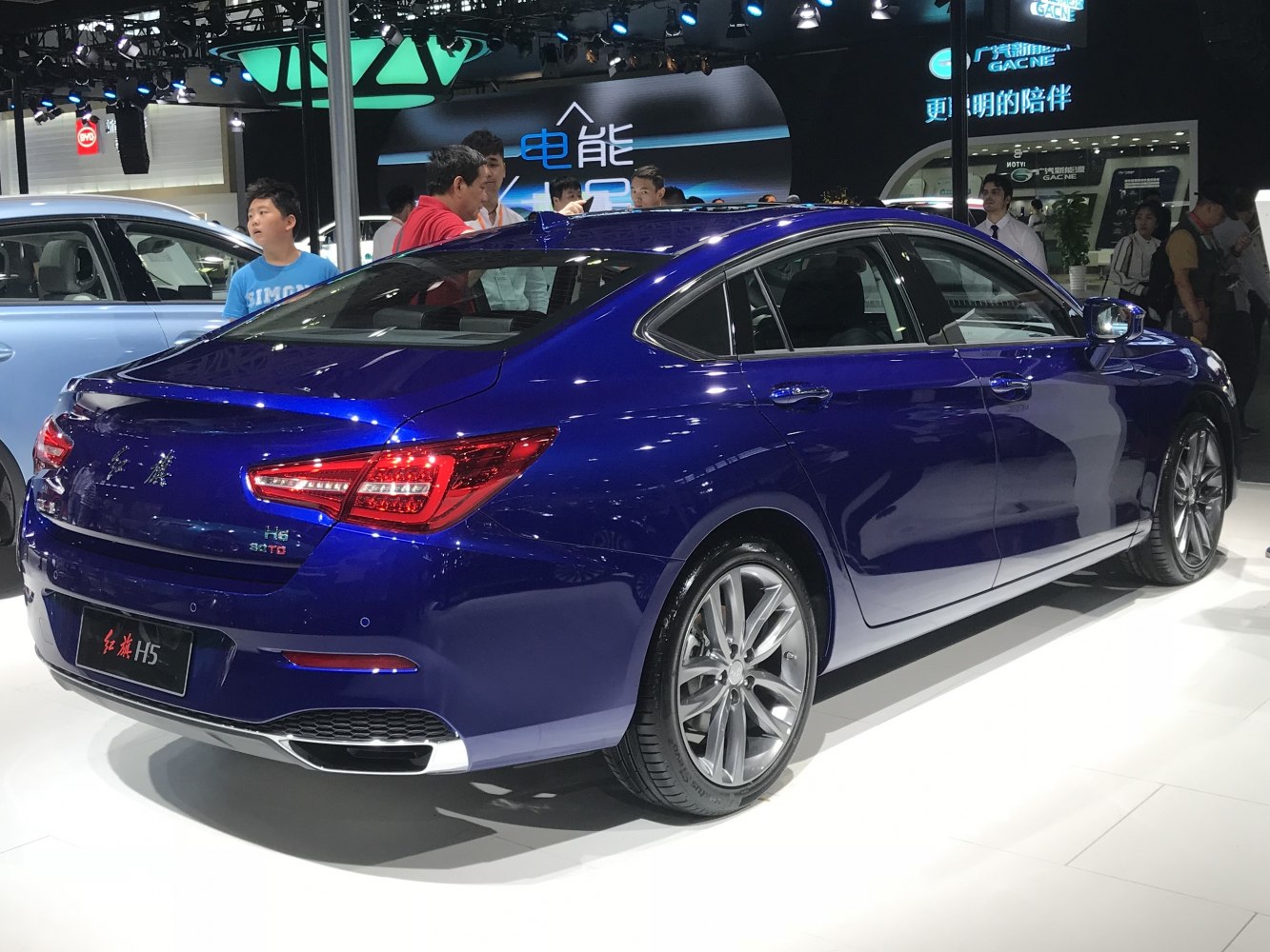 Luxury sedan rear side view with alloy wheels and distinctive taillights