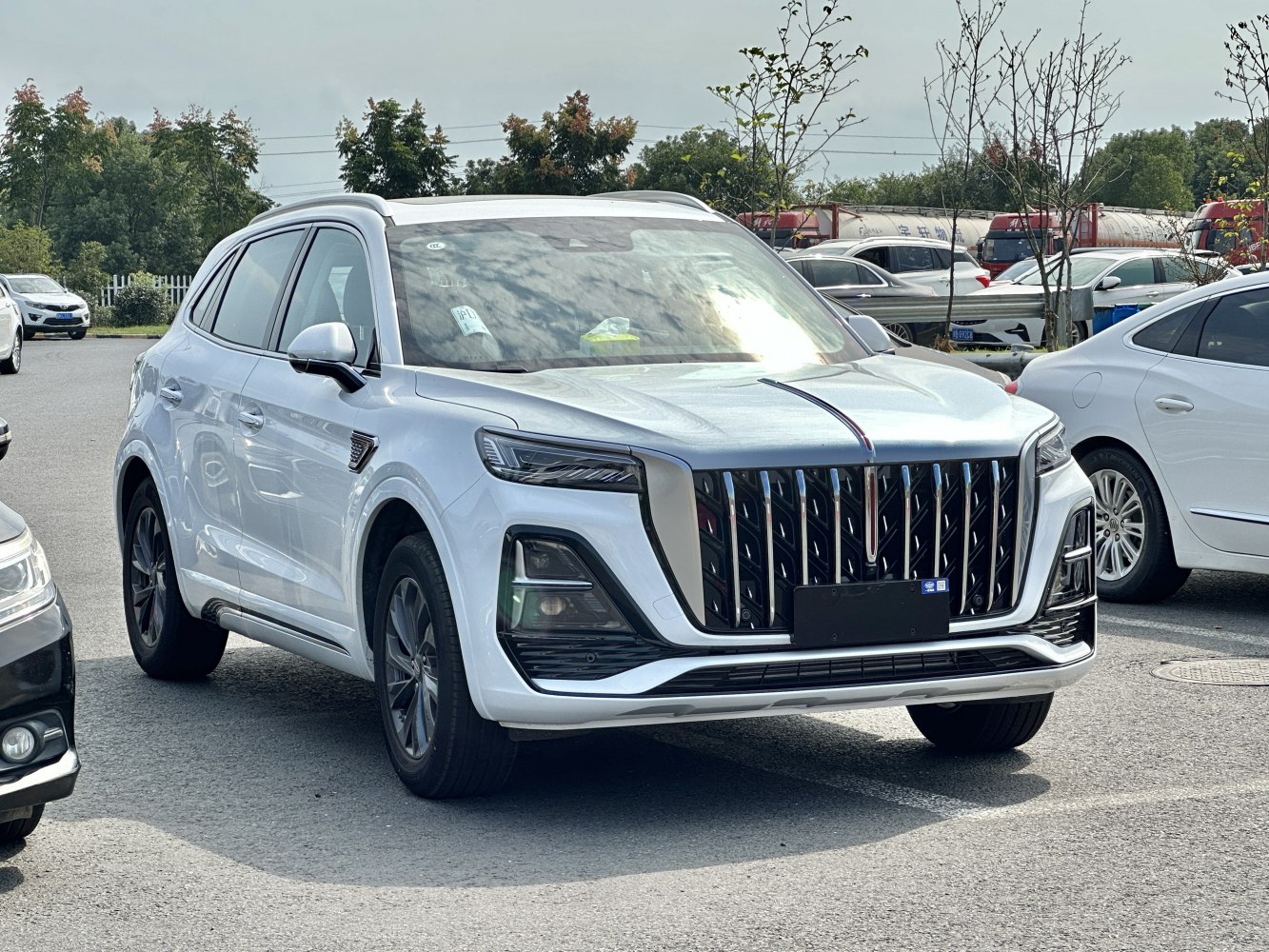 Large vertical front grille and sleek multi-element headlights on a modern SUV