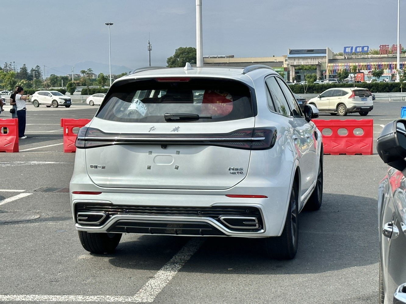 Rear view of a modern SUV with integrated full-width tail light and distinct exhaust design.
