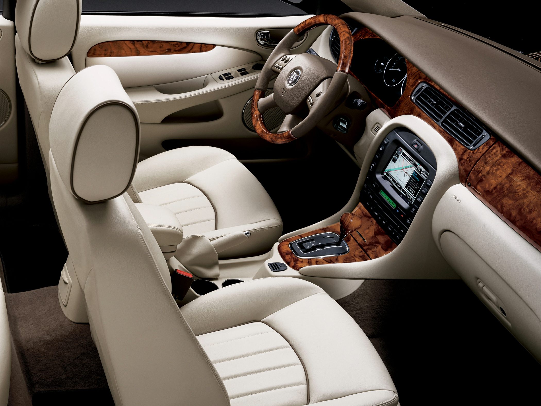 Beige leather seats and wood trim dashboard with navigation system and automatic gear shift