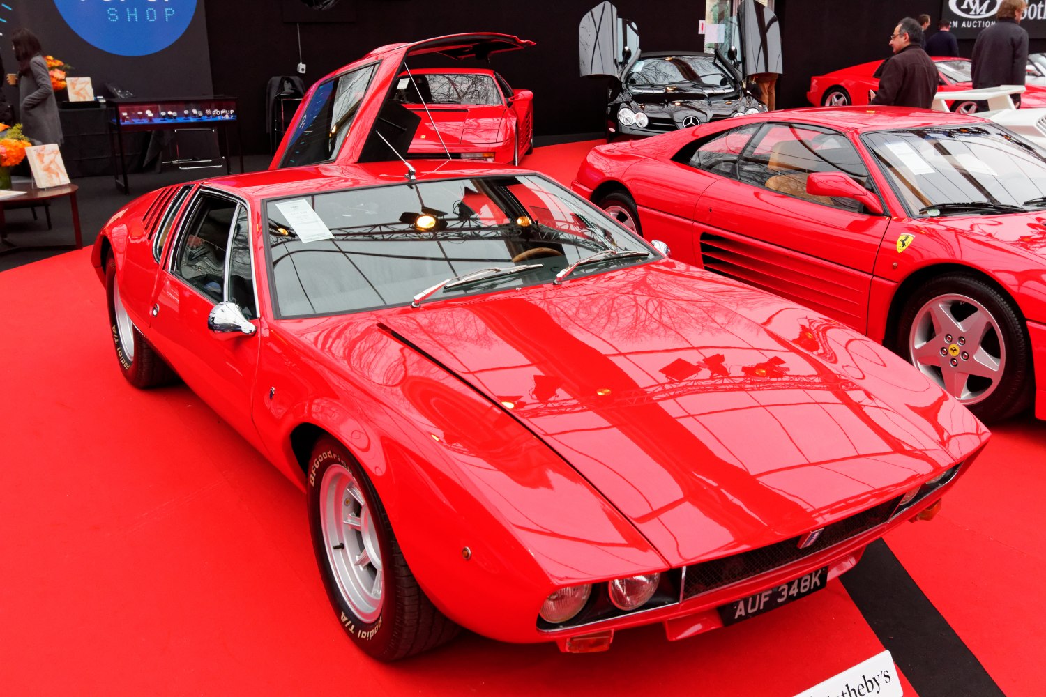 Red sports car with gullwing doors and dual headlights