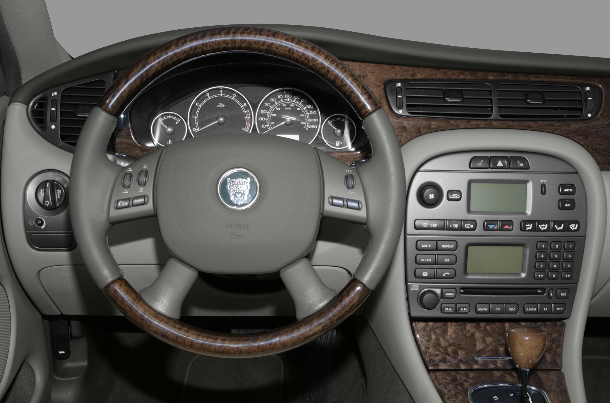 Steering wheel and wood-trimmed dashboard with instrument cluster and control panel